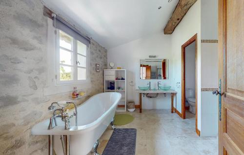 een badkamer met een bad en een wastafel bij Nice Home In Armillac With Jacuzzi in Armillac