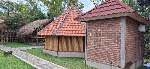 a small brick building with a red roof at Uma Nirmala Aling-Aling in Singaraja