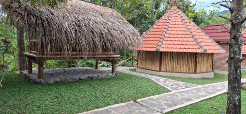 a pavilion and a hut with a red roof at Uma Nirmala Aling-Aling in Singaraja