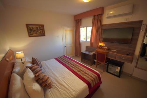 a bedroom with a bed and a desk and a television at Petra Plaza Hotel in Wadi Musa