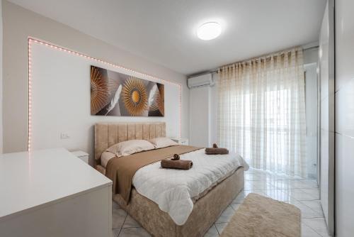 a bedroom with a bed with two towels on it at Premium Sea View Big Apartament in Durrës
