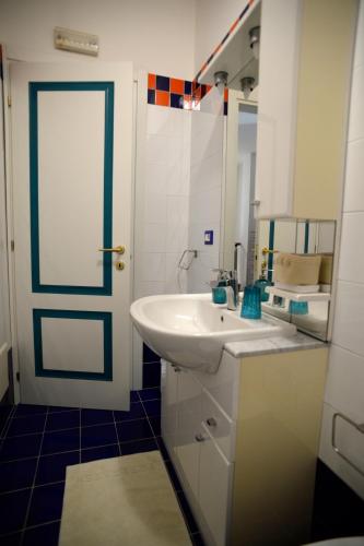 a bathroom with a white sink and a door at Il Sestante B&B in Condofuri