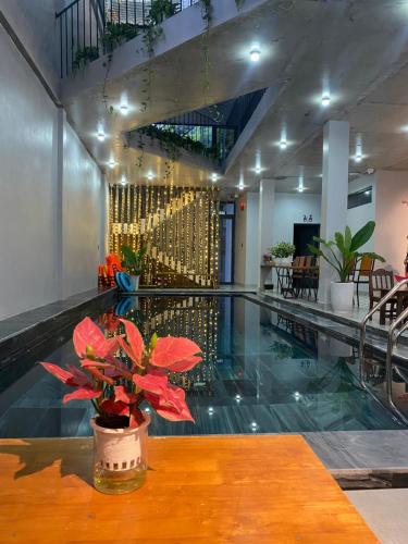 a swimming pool with a vase of flowers on a table at Celia Boutique Hotel in Phong Nha
