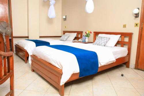 two twin beds in a room with at Paris Hotel in Nairobi