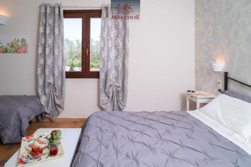 a bedroom with a bed and a table with a tray of food at Il Marchese Hotel & Spa in Sciacca