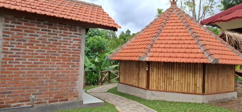 a building with an orange roof next to a brick wall at Uma Nirmala Aling-Aling in Singaraja