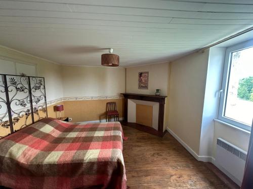 - une chambre avec un lit, une cheminée et une fenêtre dans l'établissement Appart' bucolique en plein centre ville, à Condom
