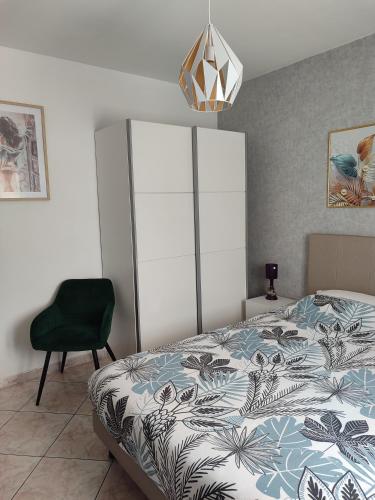 a bedroom with a bed and a green chair at Petit cocon in Fos-sur-Mer