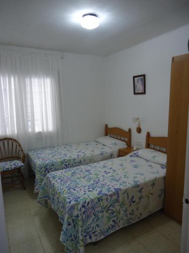 a room with two beds and a chair in it at brisa mar in San Pol de Mar