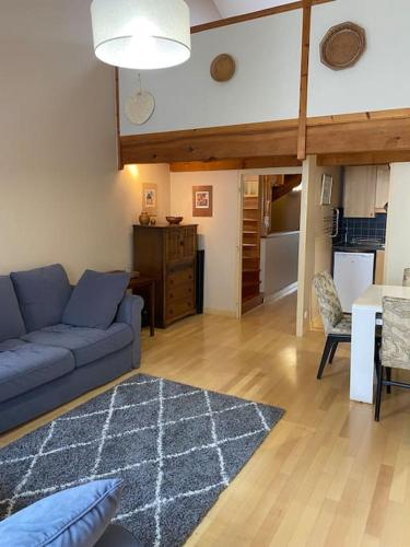 un salon avec un canapé bleu et une table dans l'établissement Appartement au calme sur le Vieux port, à La Rochelle