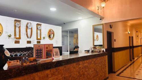 a restaurant with a counter with clocks on the wall at Turtle Beach Resort in Al Ḩadd