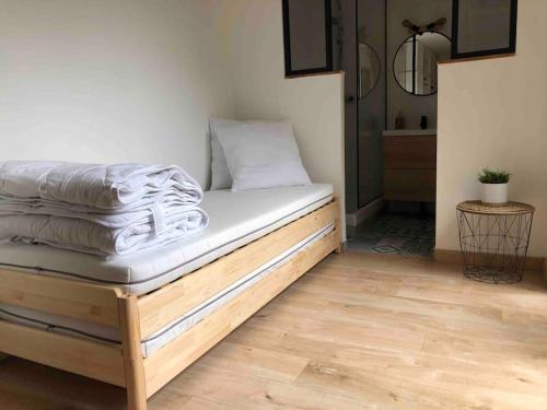a bed with white sheets on it in a room at Magnifique Maison de Ville in Lormont