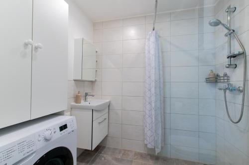a white bathroom with a shower and a sink at Parkside Central Apartment by Kuus Sõlme in Kuressaare