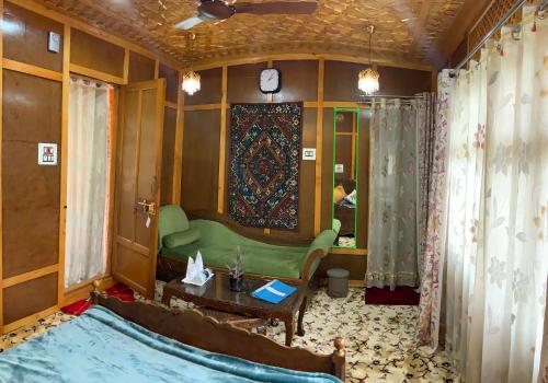 a living room with a green couch and a table at Movie land group of house boats in Srinagar