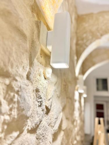 a light on the side of a stone wall at MCC St Rita in Il-Furjana