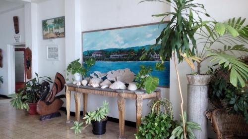 a room with a table with plants and a painting at Silver Seas Hotel in Ocho Rios