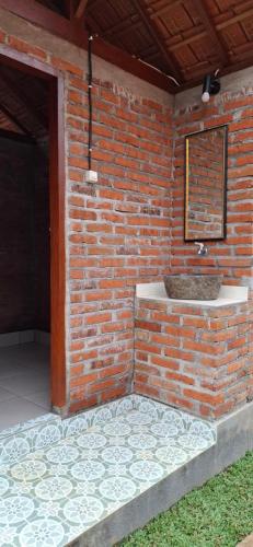 a bathroom with a brick wall with a sink at Uma Nirmala Aling-Aling in Singaraja