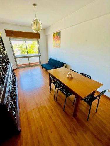 a living room with a wooden table and a blue couch at Apartamento Faro - T3 in Faro