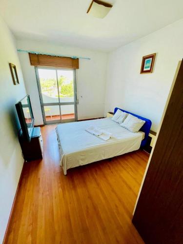 a bedroom with a white bed and a window at Apartamento Faro - T3 in Faro