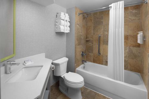 a bathroom with a toilet and a tub and a sink at Hampton Inn Cleveland-Downtown in Cleveland