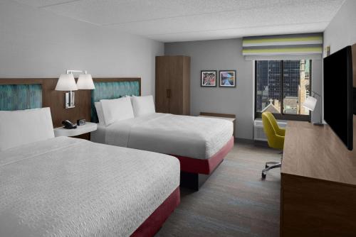 a hotel room with two beds and a desk at Hampton Inn Cleveland-Downtown in Cleveland