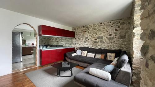un salon avec un canapé et un mur en pierre dans l'établissement Duplex 4br - 1,5km beach - WIFI/VOD - AirCond, à Biarritz