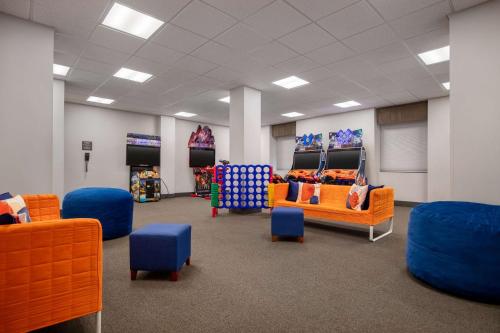 a room with orange and blue furniture and chairs at Hampton Inn Long Island-Brookhaven in Farmingville