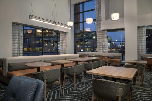 un restaurant avec des tables, des chaises et des fenêtres dans l'établissement Homewood Suites by Hilton Omaha - Downtown, à Omaha