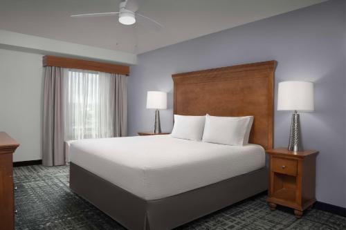 a hotel room with a bed and two lamps at Homewood Suites by Hilton Omaha - Downtown in Omaha