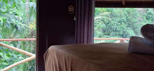 a bedroom with a bed and a large window at Uma Nirmala Aling-Aling in Singaraja