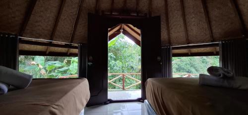 a room with two beds and an open window at Uma Nirmala Aling-Aling in Singaraja
