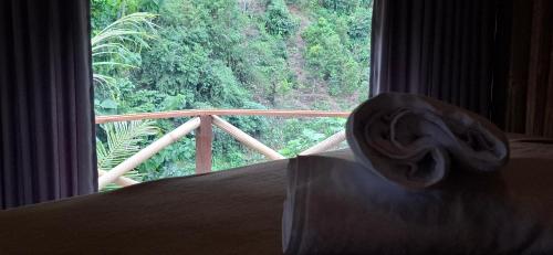 a room with a large window with a hat on a bed at Uma Nirmala Aling-Aling in Singaraja