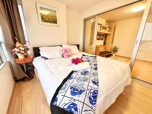 a bedroom with a bed with flowers on it at เช่ารายเดือน DCon Rattanathibet in Ban Sai Ma