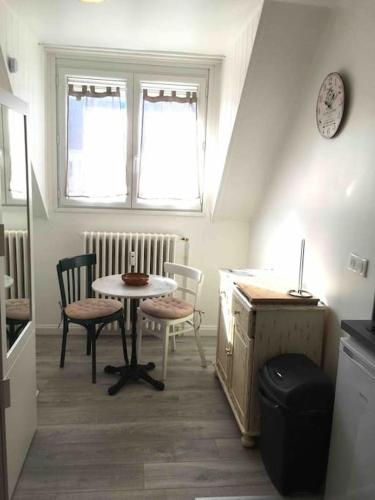 une cuisine avec une table, deux chaises et une horloge dans l'établissement Studio RETRO, à Chambéry