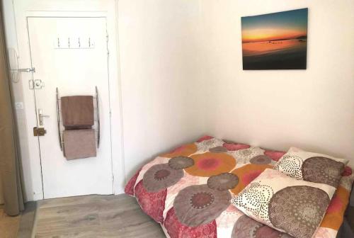 une chambre avec un lit avec une couette dessus dans l'établissement Studio RETRO, à Chambéry