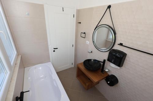 bagno con lavandino e specchio a parete di Baza Hostel - Swimming Pool a Berat