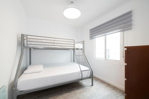 Un dormitorio con una litera y una ventana. en BrisaMar III en segunda línea de playa, en Rincón de la Victoria