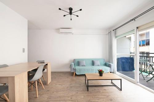 Una sala de estar con una mesa y un sofá azul. en BrisaMar III en segunda línea de playa, en Rincón de la Victoria