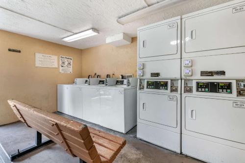 a laundry room with washing machines and a bench at Clarion Inn Orlando International Drive - ICON Park in Orlando