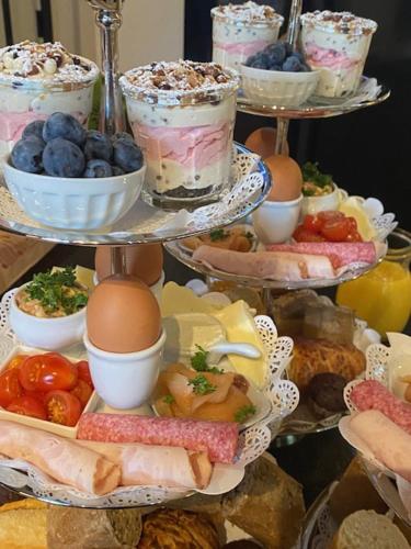 a three tiered tray of food with eggs and fruit at Mansion9Bruges in Bruges