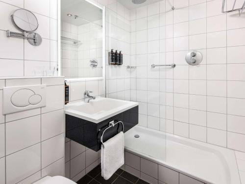 Mercure Birmingham West Hotel في ويست برومويتش: حمام أبيض مع حوض ومرحاض
