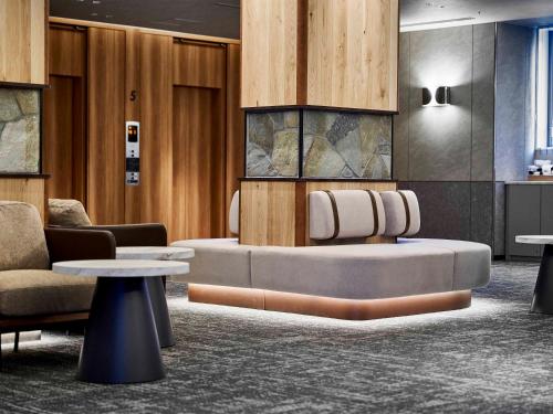 a lobby with a couch and chairs and tables at Daiwa Roynet Hotel Wakayama in Wakayama