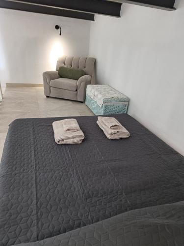 a bedroom with a bed and a couch at Room in Ain Karem - A Maltese Traditional Townhouse in Mosta