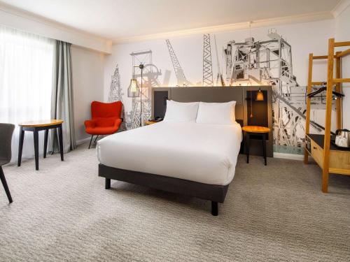 a hotel room with a bed and a chair at Mercure Cardiff North Hotel in Cardiff