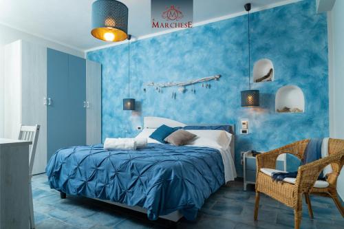 a blue bedroom with a bed and a chair at Il Marchese Hotel & Spa in Sciacca