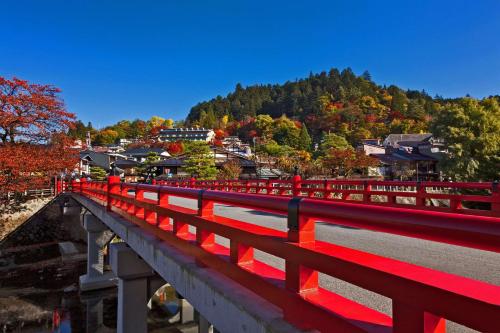 a red fence on a bridge with a mountain at hotel around TAKAYAMA, Ascend Hotel Collection in Takayama