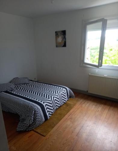 - une chambre avec une couette en noir et blanc sur un lit dans l'établissement Location saisonnière par nuitée, à Duran