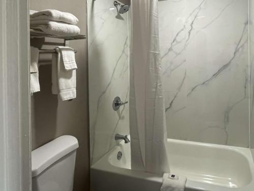 a bathroom with a shower and a toilet at Motel 6 Greenwood, MS in Greenwood