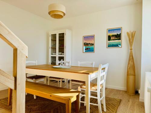 une salle à manger avec une table et des chaises en bois dans l'établissement Bord de mer en Bretagne Sud, à Névez