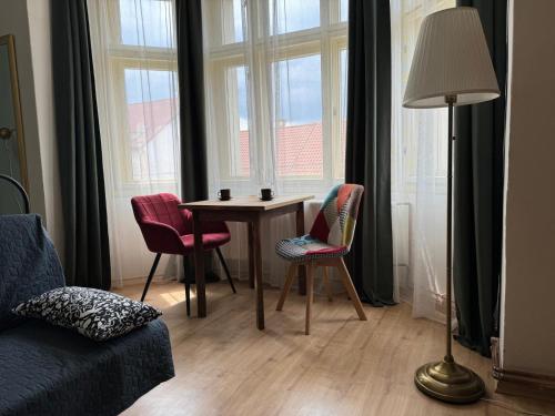 a living room with a table and chairs and a lamp at Apartments Bouquet in Prague